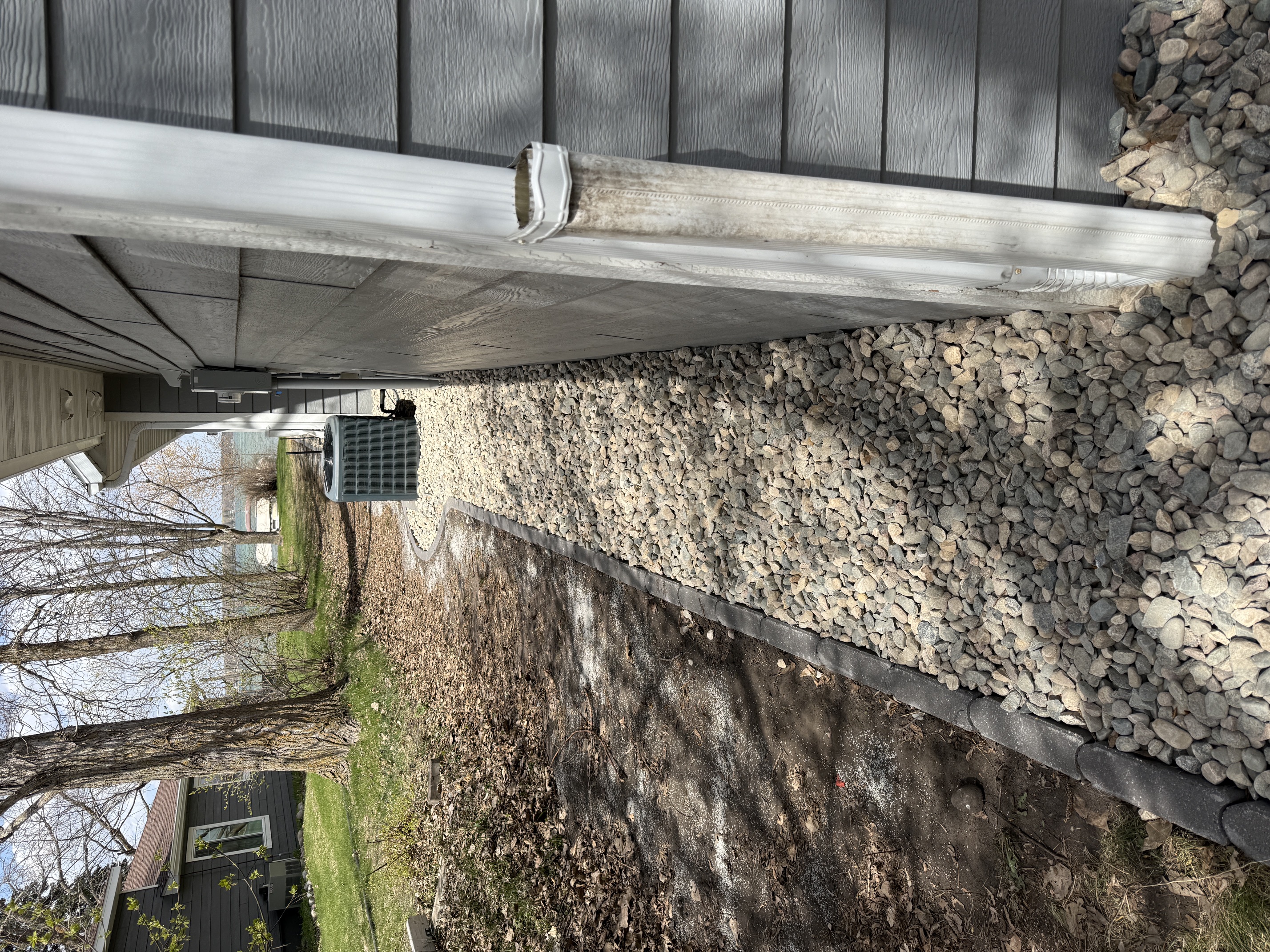 Rock and gravel border along a home foundation with landscape edging