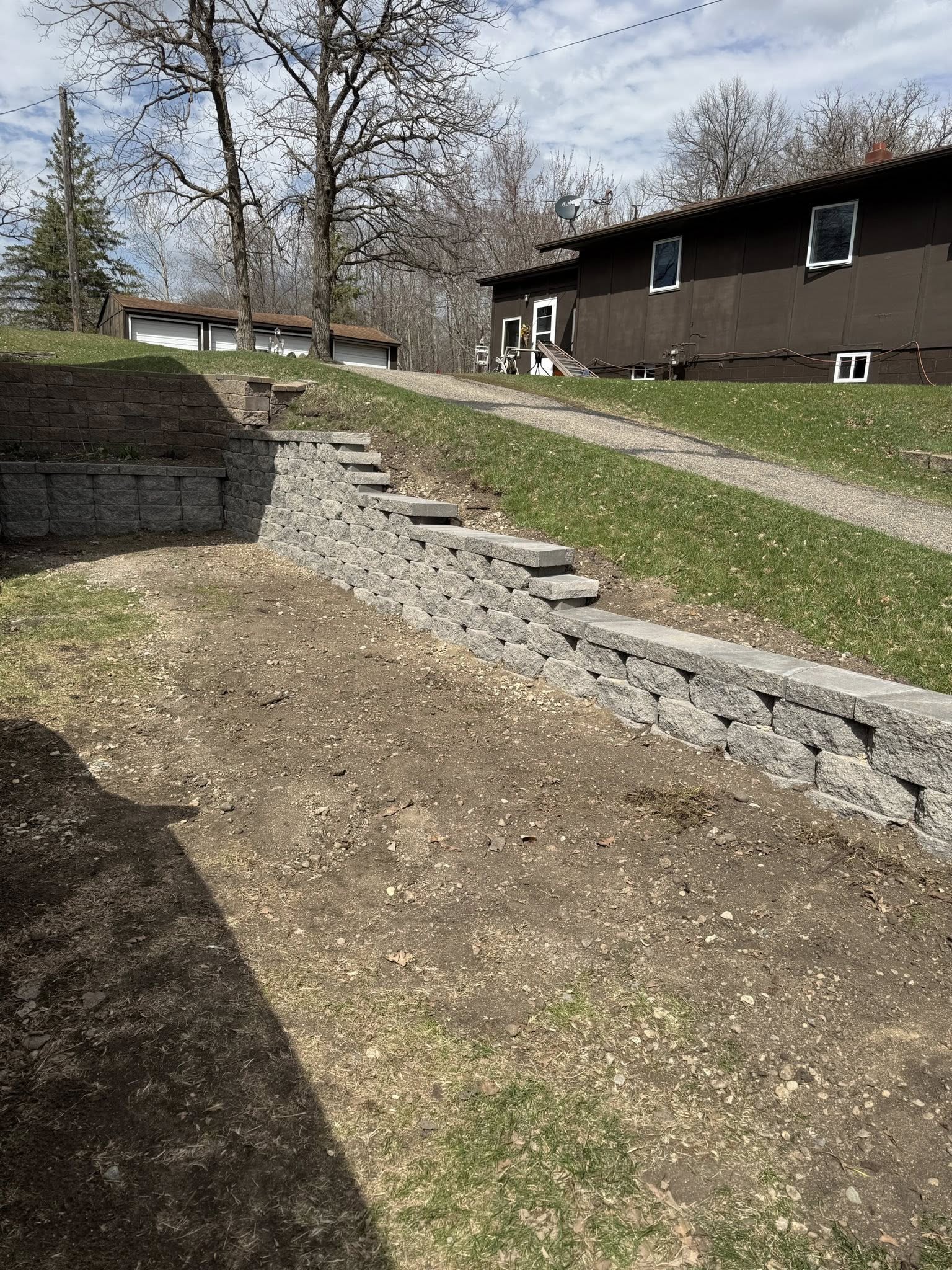 Curved stone retaining wall built on a hillside residential property